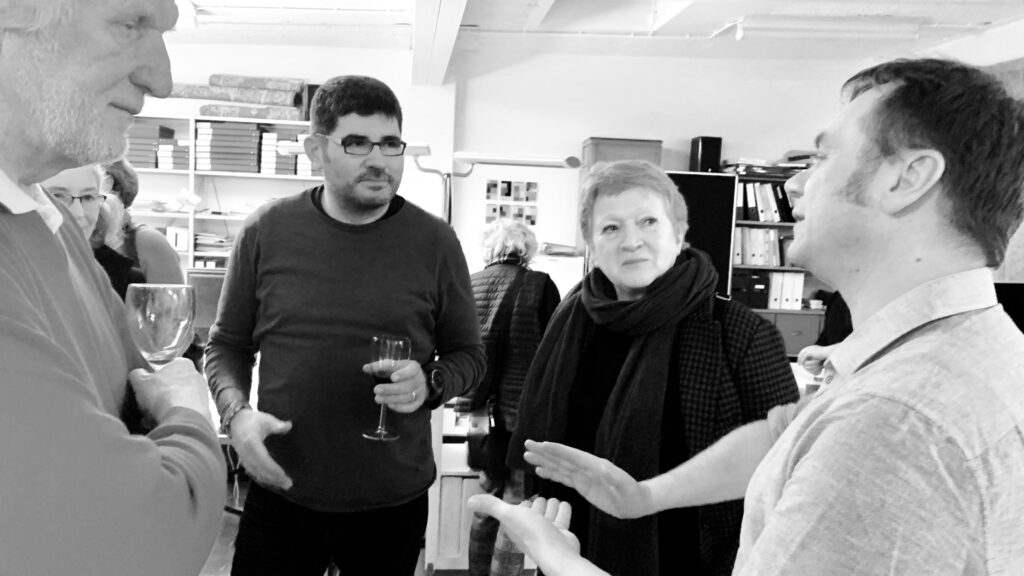 schwarz weisses Foto mit drei Personen und Künstler Michael Graeve, Hintergrrund Büro